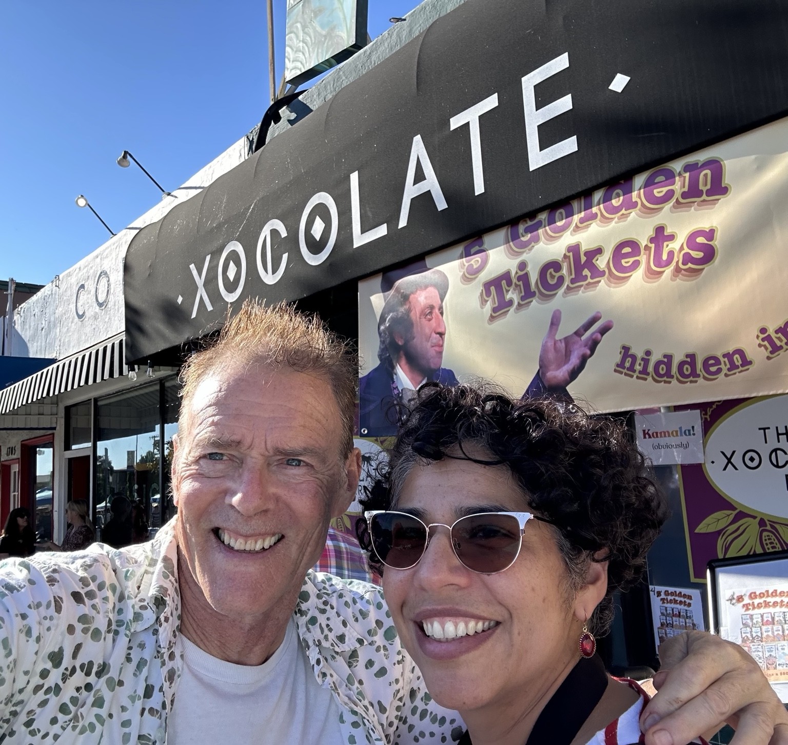 Malena and Clive smiling outside The Xocolate Bar at a Golden Tickets event.
